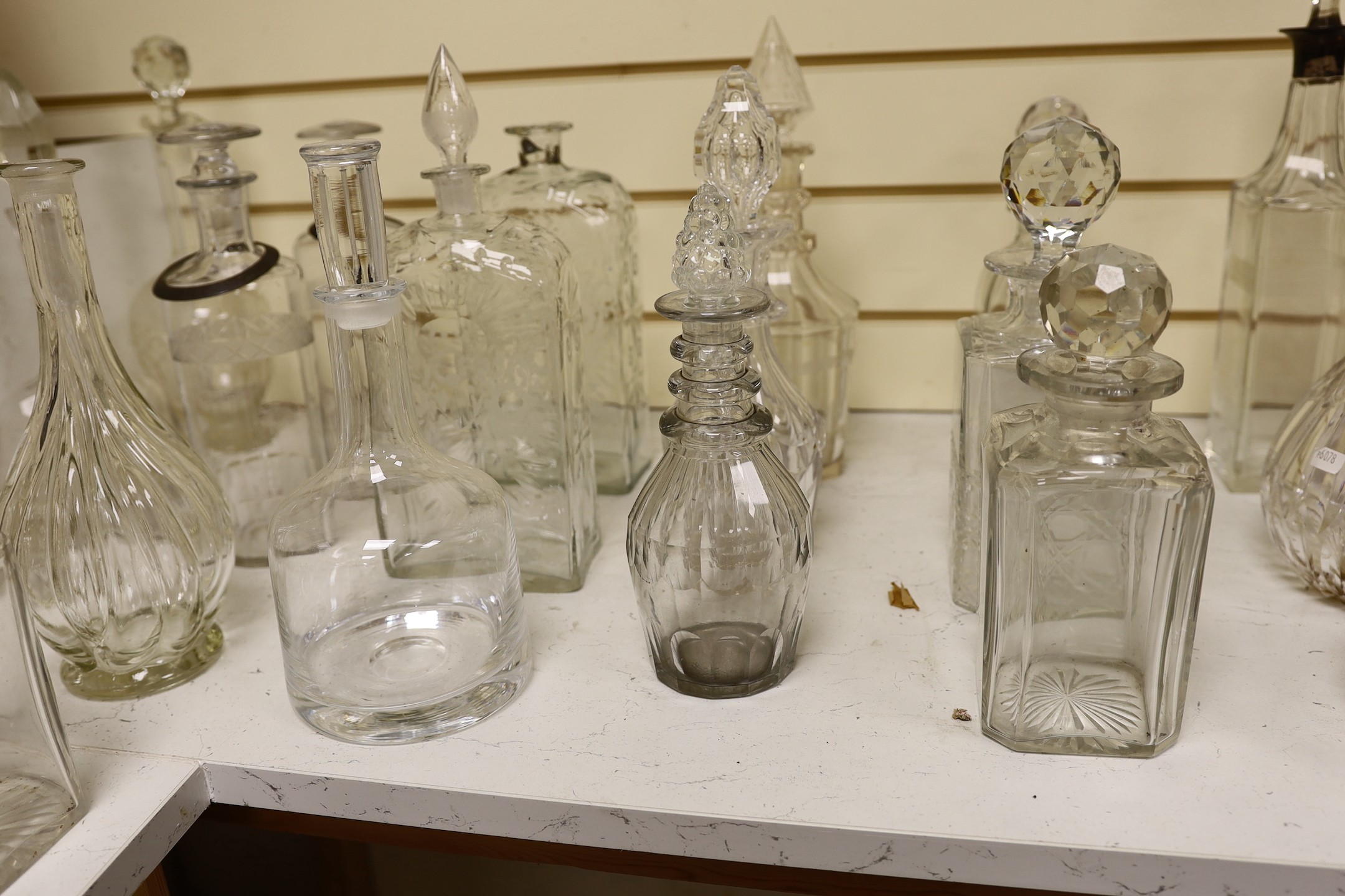 A quantity of various glass decanters, some silver mounted